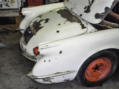 1954 Corvette rear quarter showing paint peeling and fiberglass condition before restoration