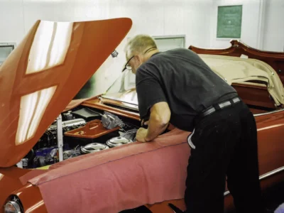 Technician installing red interior upholstery in 1954 Corvette at Corvette Connection