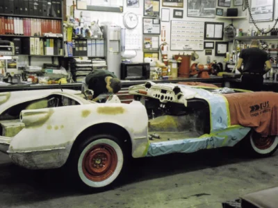 1954 Corvette body on rolling chassis with red wheels during assembly at Corvette Connection