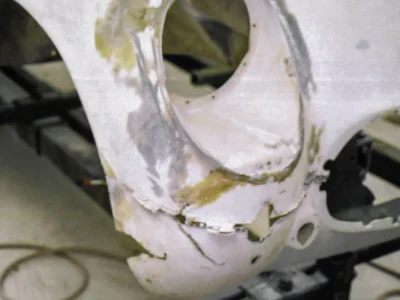 1954 Corvette headlight bucket repaired and in primer hanging for paint