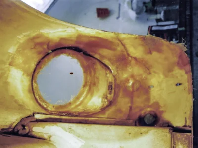 1954 Corvette headlight bucket area showing fiberglass repair and body filler during restoration