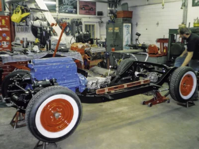 1954 Corvette red wheel with whitewall tire mounted on restored rolling chassis