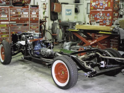 1954 Corvette rolling chassis with red wheels and whitewall tires at Corvette Connection