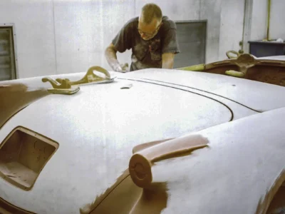 Technician wet sanding 1954 Corvette body between paint coats at Corvette Connection