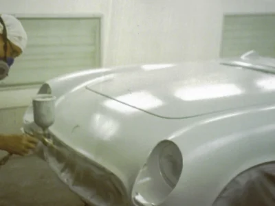 1954 Corvette body in white paint rear view in paint booth showing smooth finish