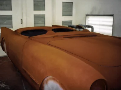 1954 Corvette body in red primer base coat in paint booth at Corvette Connection
