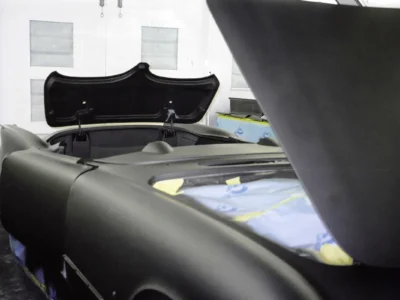 1954 Corvette body with black sealer and masking in paint booth at Corvette Connection