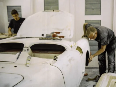 Technicians fitting body panels on 1954 Corvette in white paint at Corvette Connection