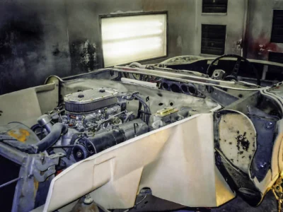 1957 Corvette engine bay and inner fender area stripped to bare fiberglass during restoration