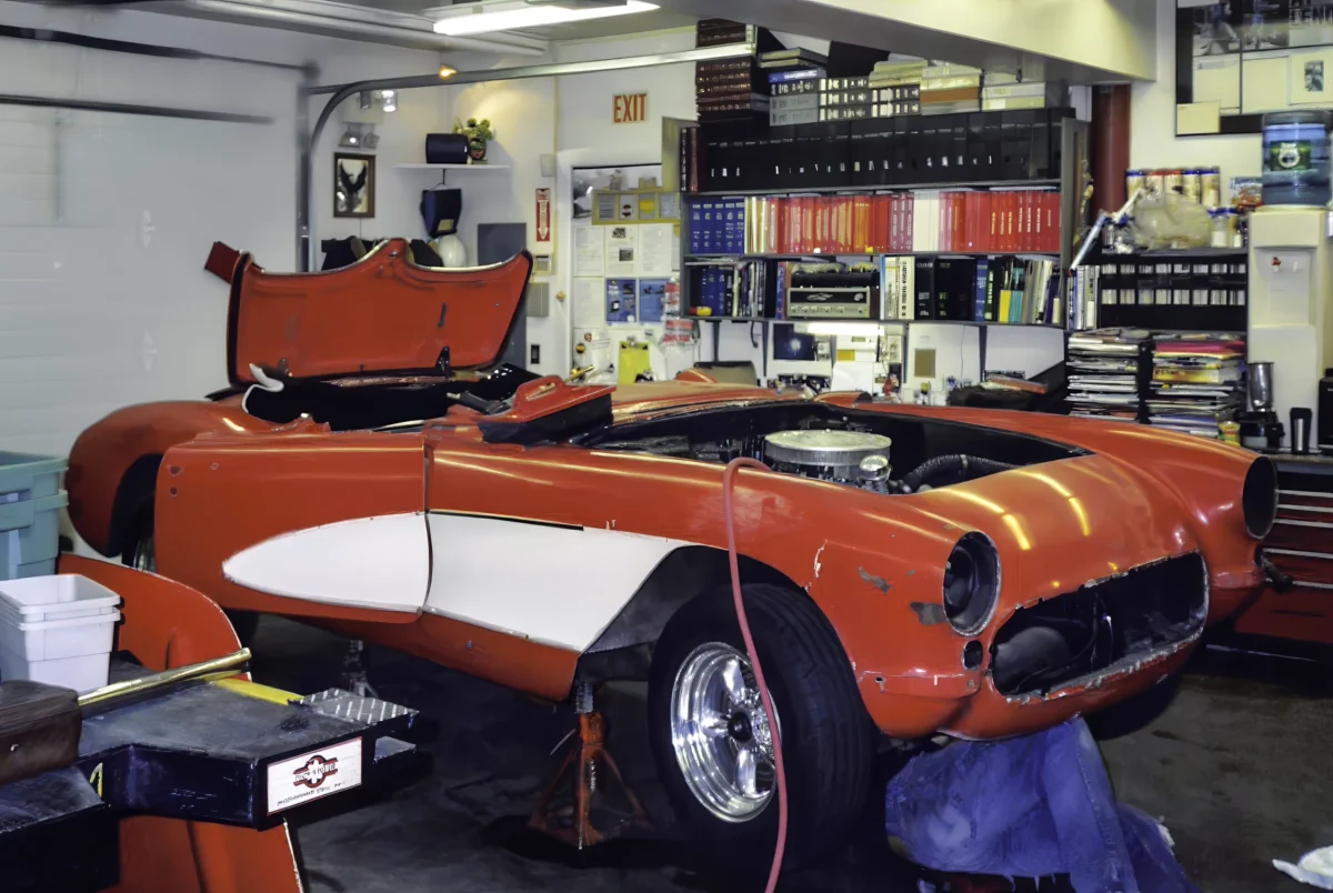 1957 Corvette in red and white front three-quarter view during reassembly at Corvette Connection