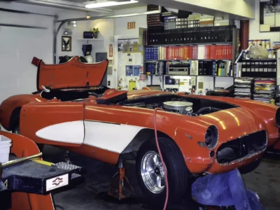 1957 Corvette in red and white front three-quarter view during reassembly at Corvette Connection