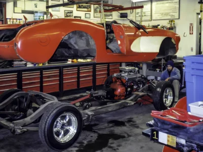1957 Corvette in red and white during reassembly on rolling chassis at Corvette Connection