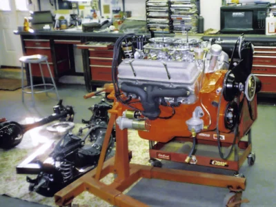 Rebuilt engine on stand with orange paint for 1957 Corvette restoration at Corvette Connection