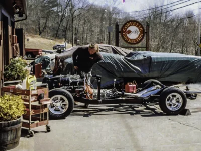 1957 Corvette rolling chassis with engine outdoors at Corvette Connection with body under cover
