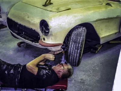 Technician fitting front fender on 1957 Corvette in primer at Corvette Connection