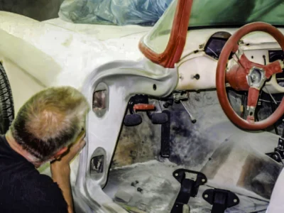 Technician working inside cockpit of 1957 Corvette during body restoration at Corvette Connection