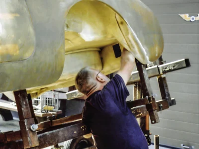 Technician working on 1957 Corvette body on rotisserie at Corvette Connection
