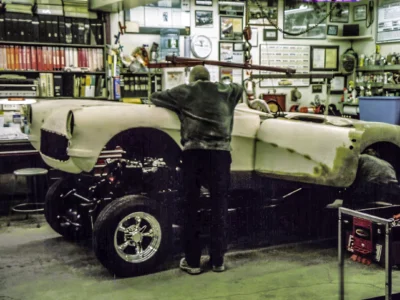 1957 Corvette in primer on jack stands in shop during body assembly