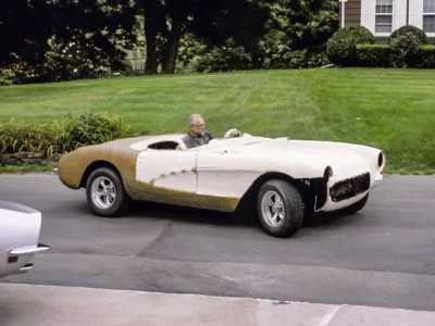1957 Corvette in primer driven outdoors to settle body panels at Corvette Connection in Bolton CT