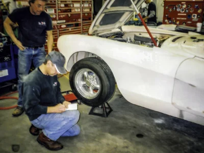 Technician checking wheel alignment on 1957 Corvette in primer at Corvette Connection