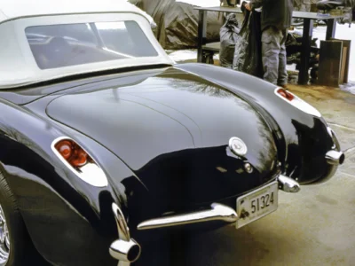 Completed 1957 Corvette in black rear quarter view showing chrome exhaust tips