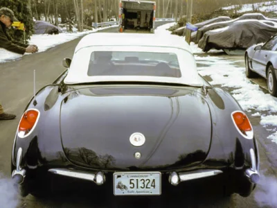 Finished 1957 Corvette in black rear view showing taillights and chrome bumper