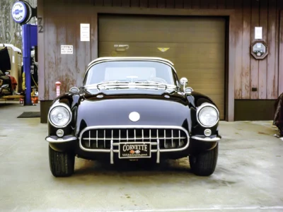 Finished 1957 Corvette in black front view close-up showing chrome grille and Corvette emblem
