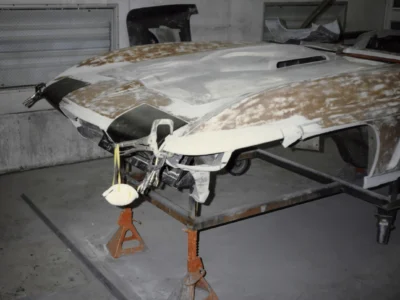 1965 Corvette hood panel showing fiberglass repair and filler work during restoration