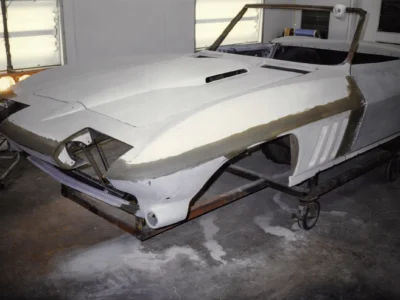 1965 Corvette body in white primer showing smooth body lines during restoration at Corvette Connection