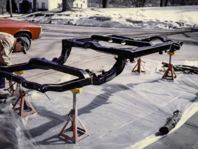 1965 Corvette restored frame in black paint on jack stands at Corvette Connection
