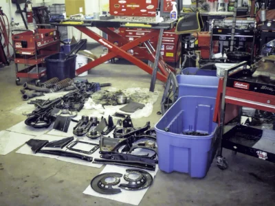 1966 Corvette frame and components organized in bins during disassembly at Corvette Connection