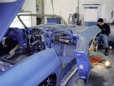 1966 Corvette Sting Ray in Nassau Blue with hood open showing engine bay during assembly