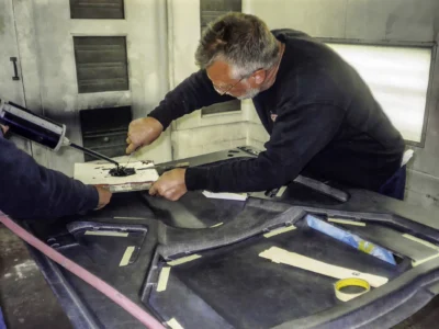 Technician sanding 1966 Corvette Sting Ray body panel during fiberglass repair at Corvette Connection