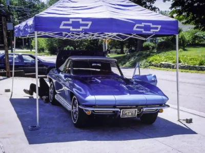 Restored 1966 Corvette Sting Ray in Nassau Blue on display under Chevrolet tent at car show