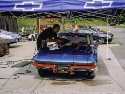 Technician polishing 1966 Corvette Sting Ray in Nassau Blue at car show