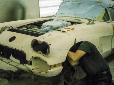 Corvette Connection technician sanding 1958 Corvette front fender during bodywork prep