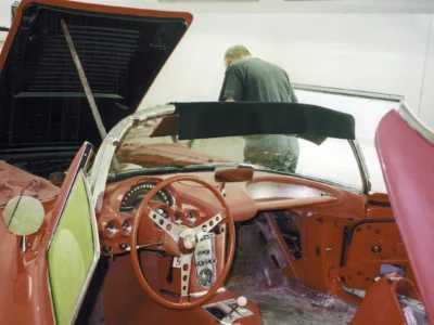 Corvette Connection technician working inside red 1958 Corvette dashboard during reassembly