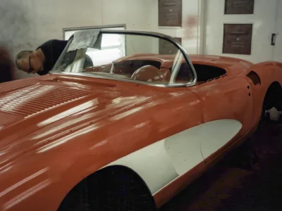 Front three-quarter of red and white 1958 Corvette during final reassembly stage