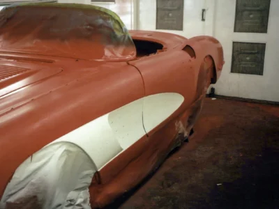 Front three-quarter of red and white 1958 Corvette during reassembly at Corvette Connection