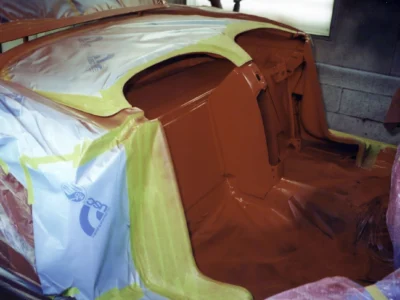 Engine bay of 1958 Corvette in red paint with cove masking during reassembly