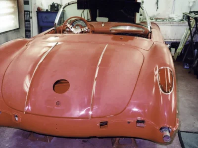 Front view of red 1958 Corvette during chrome trim reinstallation at Corvette Connection