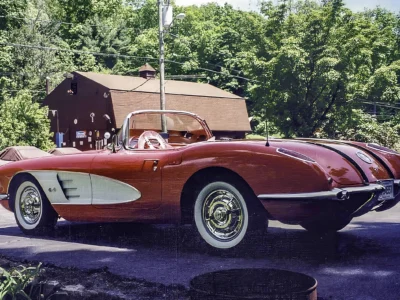 Side profile of finished red and white 1958 Corvette parked at outdoor location