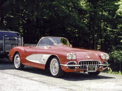 Front three-quarter of finished red and white 1958 Corvette parked outdoors