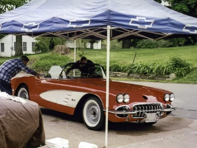 Front three-quarter of finished red and white 1958 Corvette under tent at Corvette show