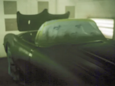 Front three-quarter of 1958 Corvette body shell with windshield frame in green primer at Corvette Connection