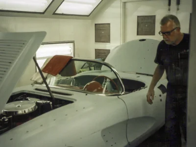 Corvette Connection technician working on 1958 Corvette body shell in white primer