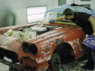 Technician sanding 1958 Corvette body shell in primer at Corvette Connection