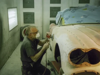 Technician with dust mask sanding 1958 Corvette front fender at Corvette Connection