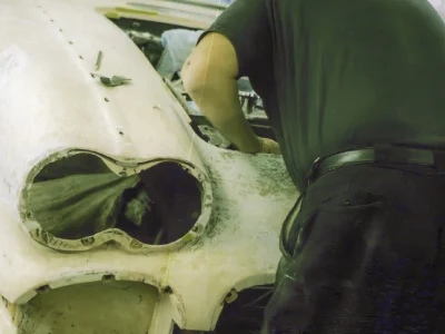 Corvette Connection technician working on 1958 Corvette body in primer during sanding