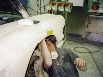 1958 Corvette body shell in white primer with hood up inside Corvette Connection paint booth